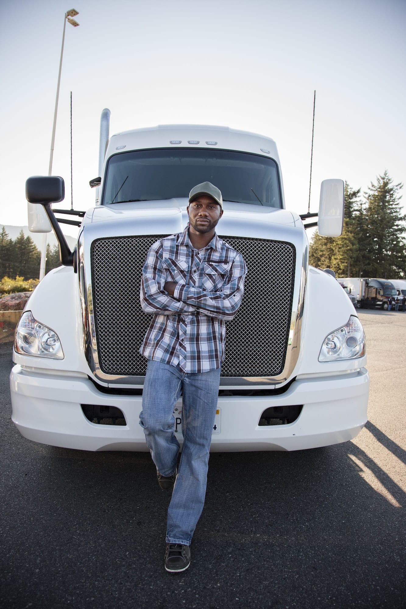 Truck driver near his truck parked in a parking lot at a truck stop