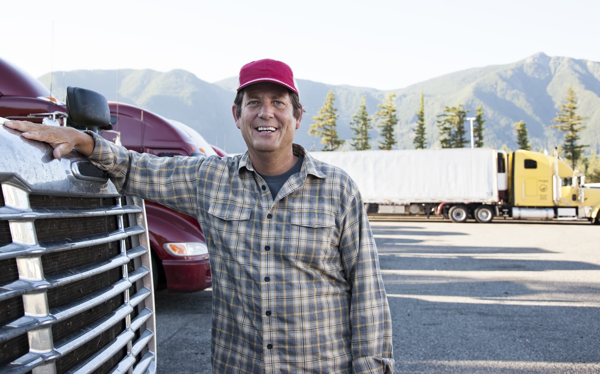 Truck driver with his truck parked in a lot at a truck stop.