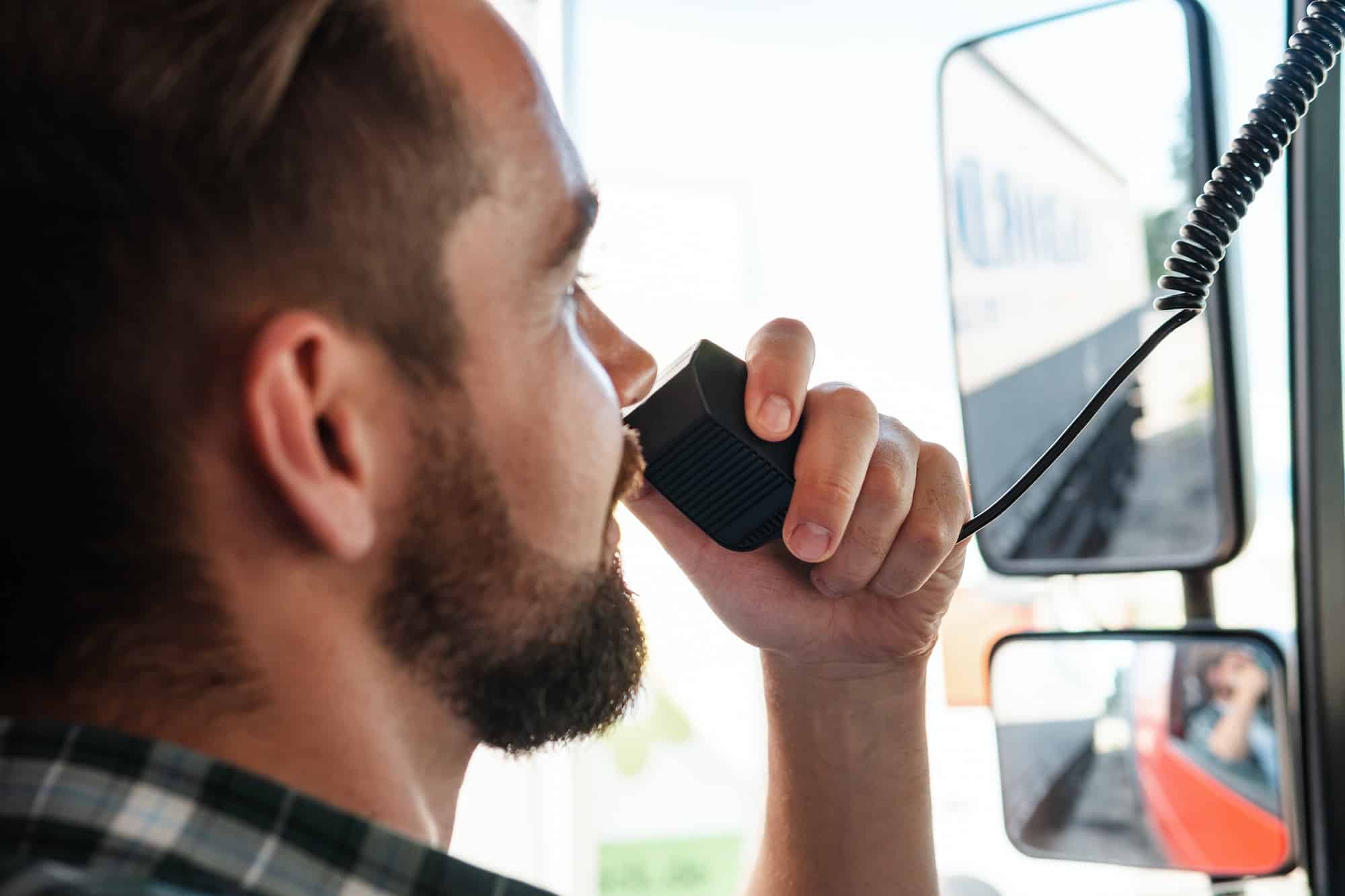 Truck driver talking by CB radio system in his vehicle